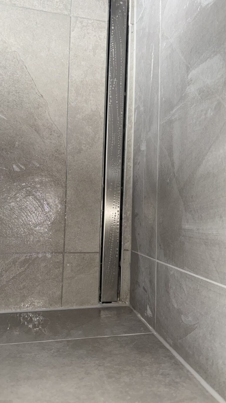 Salle de bain carrelée avec receveur de douche