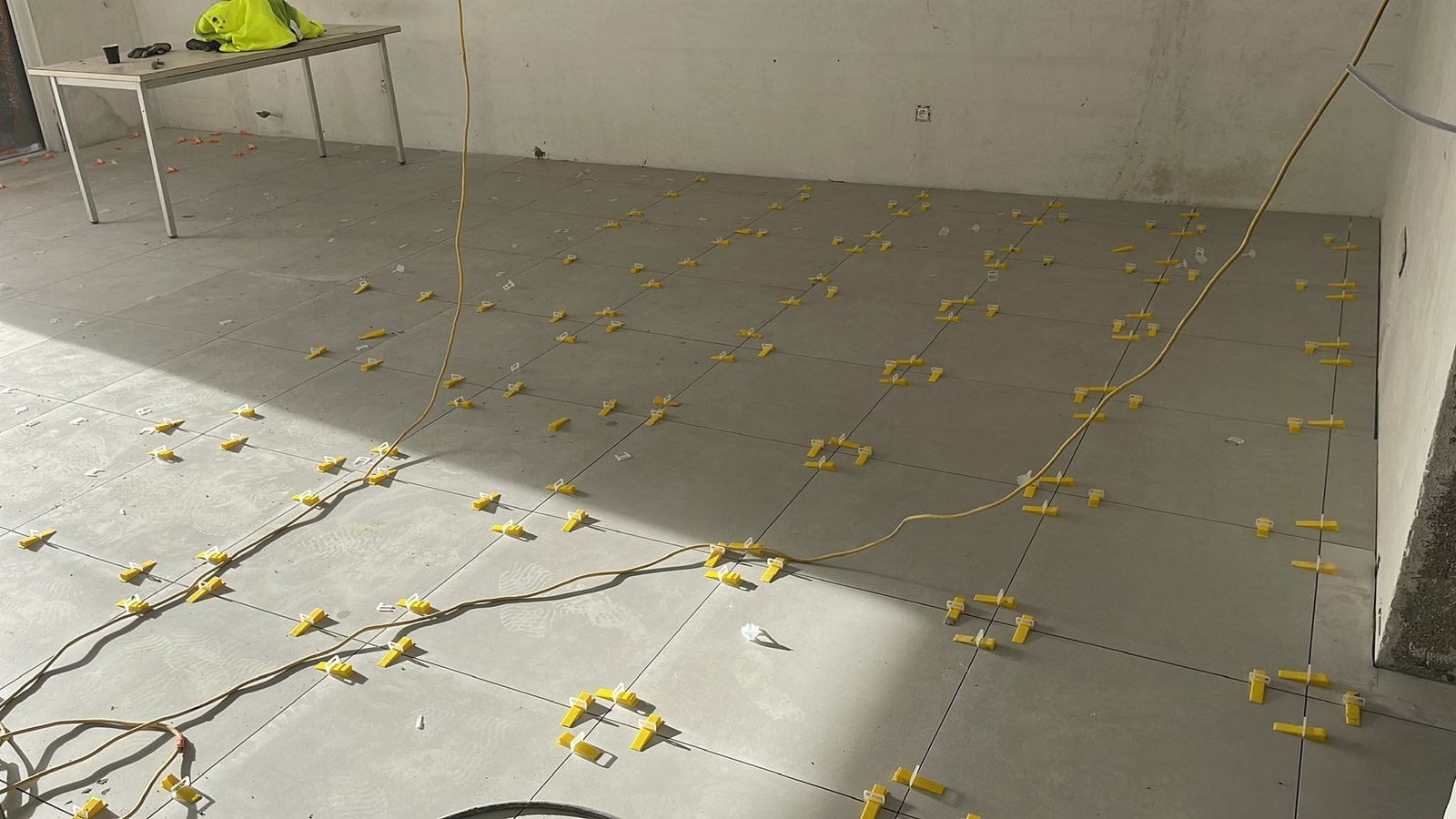 Carrelage de salon grand format avec croisillons pendant le chantier